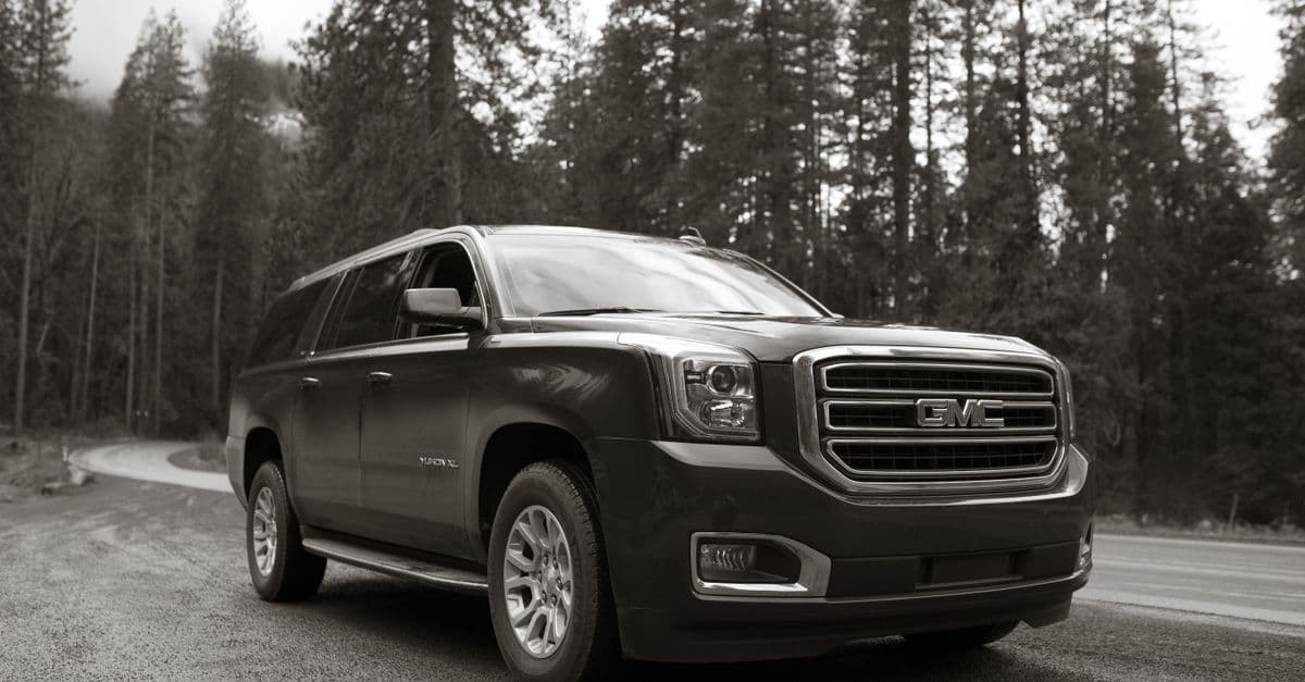 Large SUV parked on a winding forest road