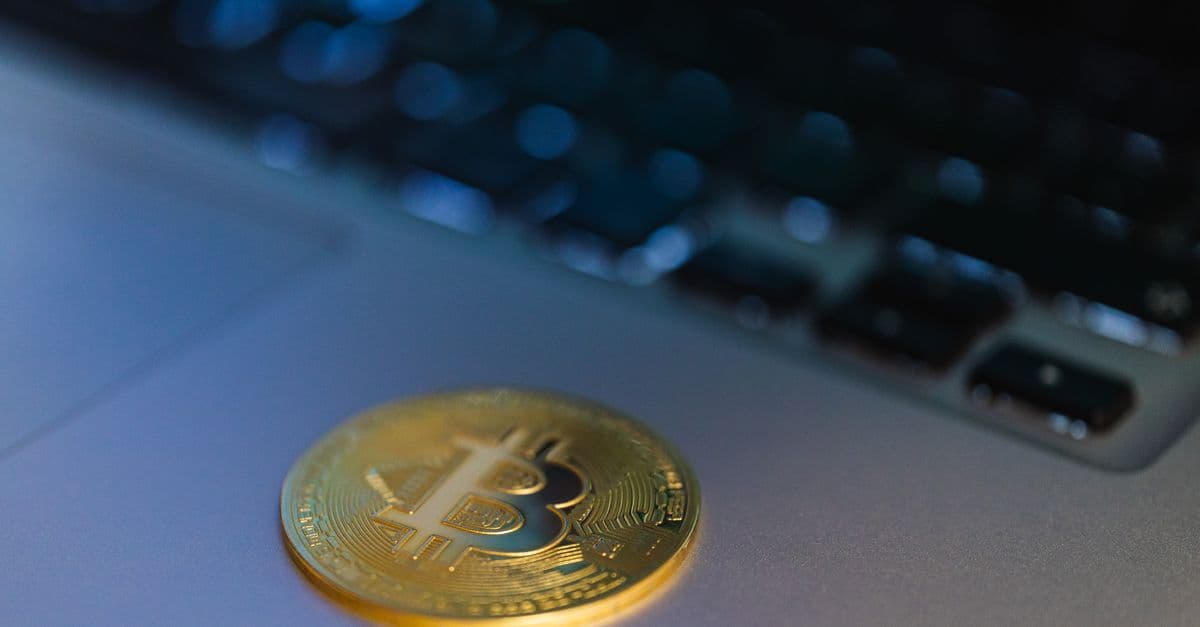 Bitcoin coin resting on a laptop keyboard
