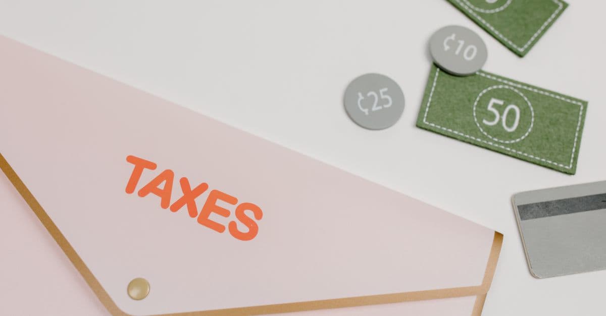 Pink envelope labeled Taxes with play money and a card