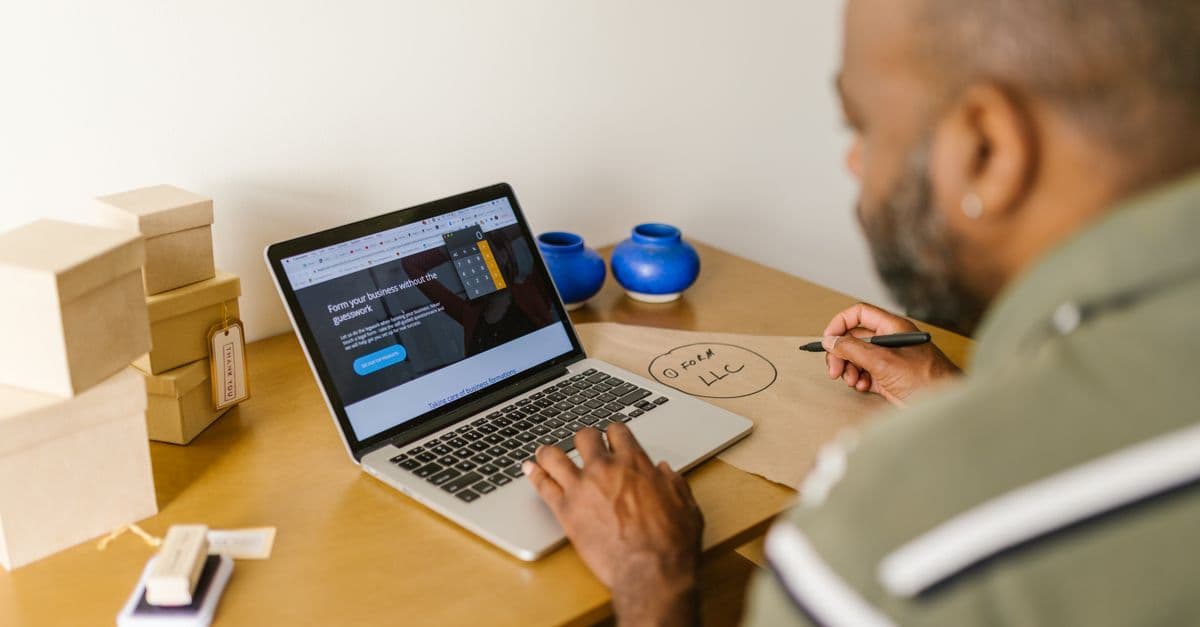 Small business owner using a laptop at his desk
